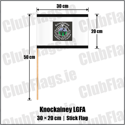 Knockainey LGFA 20cm x 30cm Stick Flag, featuring the Knockainey Ladies Football crest on black and solid white fabric with gentle vertical folds; County Limerick. ClubFlags.ie.